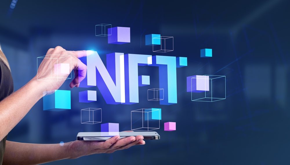 An individual interacting with floating 3D letters spelling 'NFT' emerging from a smartphone, symbolizing the advanced technology and growing trend of non-fungible tokens in the digital marketplace